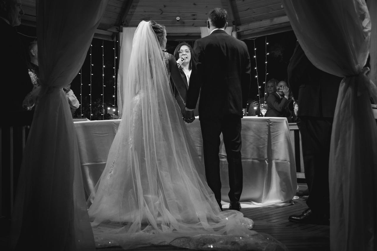 Elegant wedding ceremony with couple holding hands under romantic lighting.